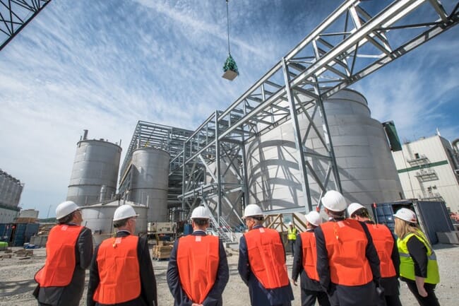 people in hi-viz waistcoats admiring a factory