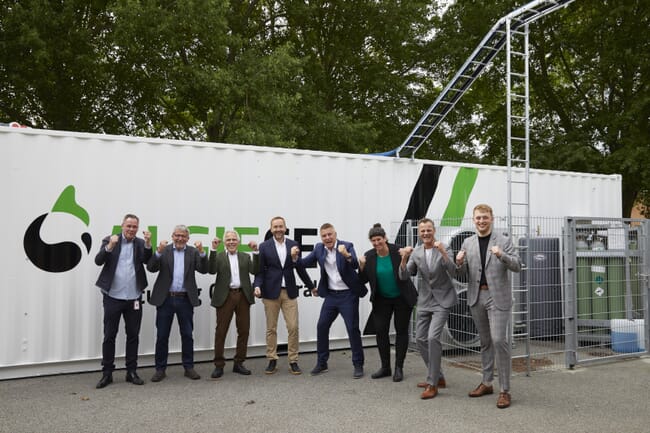 a group of men celebrating in front of a shipping container