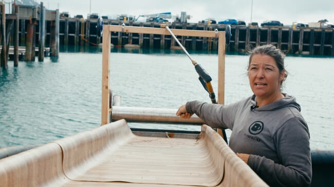 Uma mulher ao lado de uma máquina em um barco.