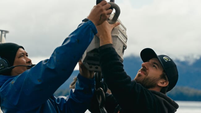 Two people reading a weighing scale.