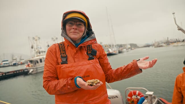 A woman holding an oyster.