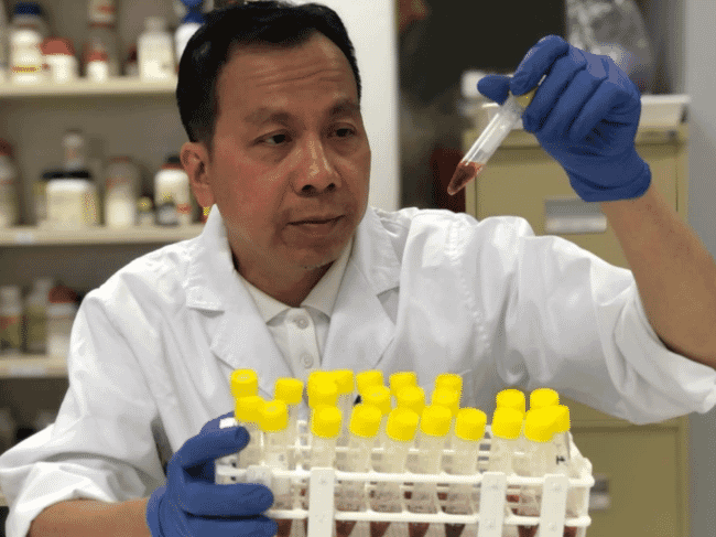 a man examining test tubes in a lab