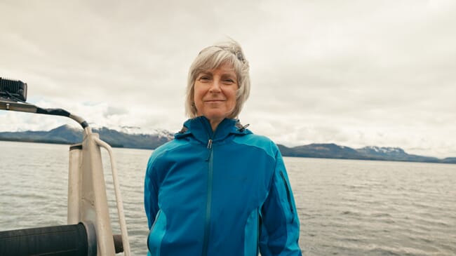 A woman speaking on the deck of a boat.