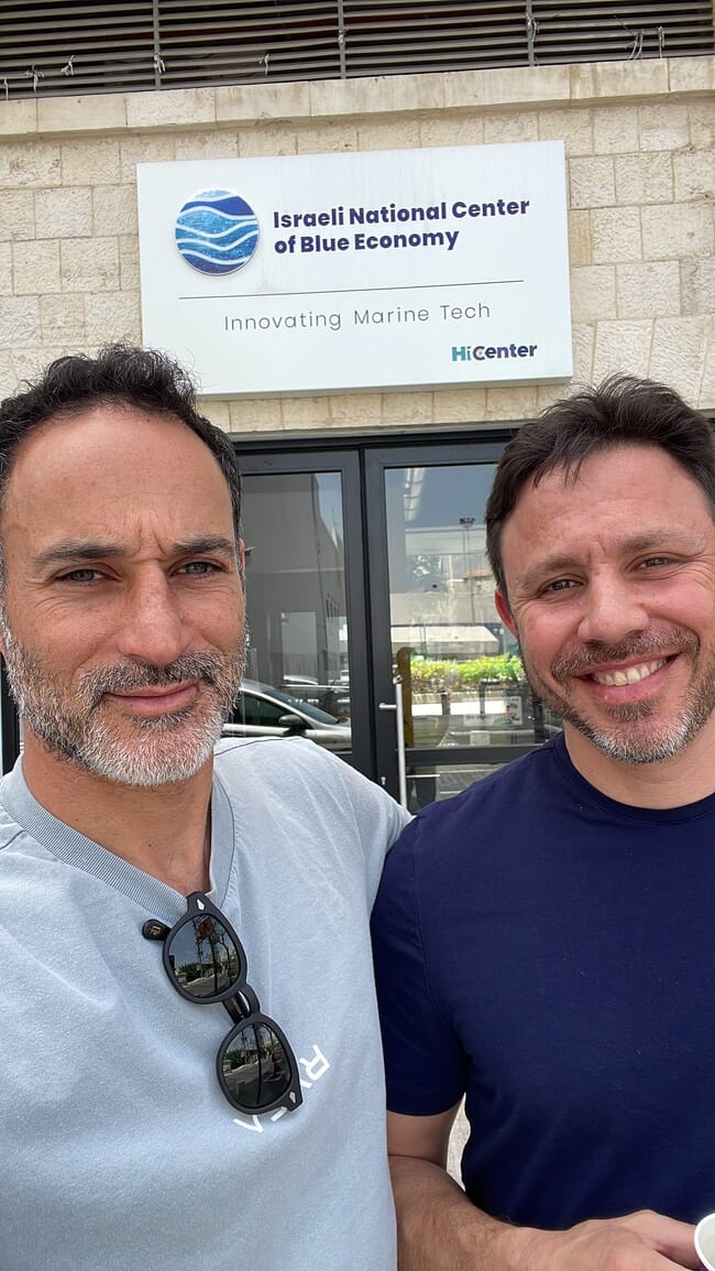 Two men standing  in front of a building.