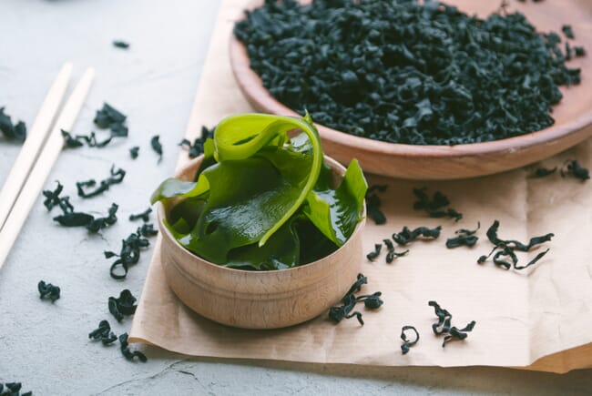 wakame and green seaweed on wooden plates