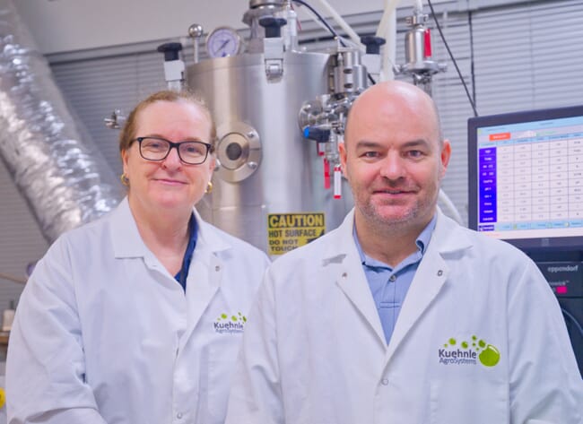 Two people wearing lab coats, in a lab.