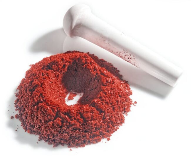 A closeup of a pile of astaxanthin on a white table.