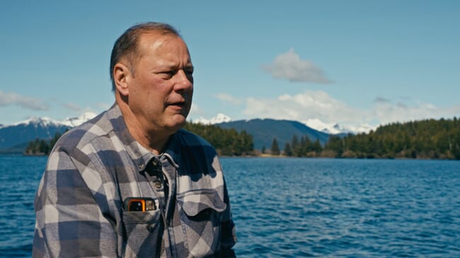 A man sitting on the deck of a boat.