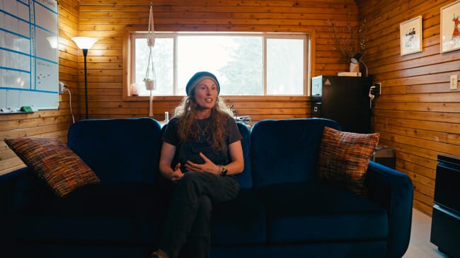 A woman sitting on a sofa in a wood-panelled office