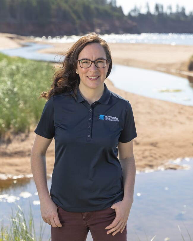 A woman standing above a sandy beach.