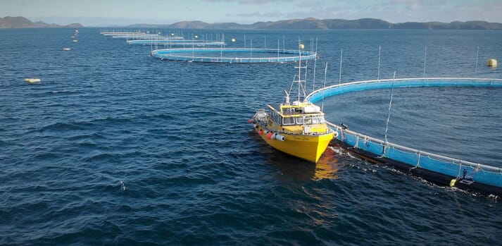 a boat moored up beside a salmon pen