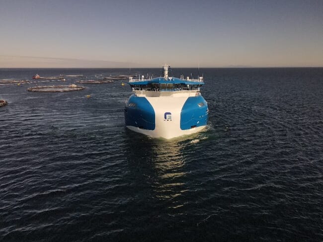 a large vessel beside some salmon pens