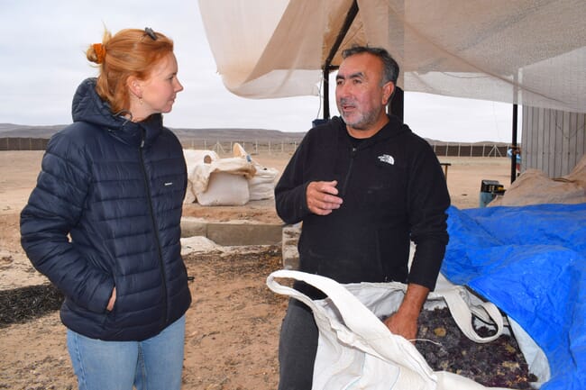 Two people talking on a seaweed farm.