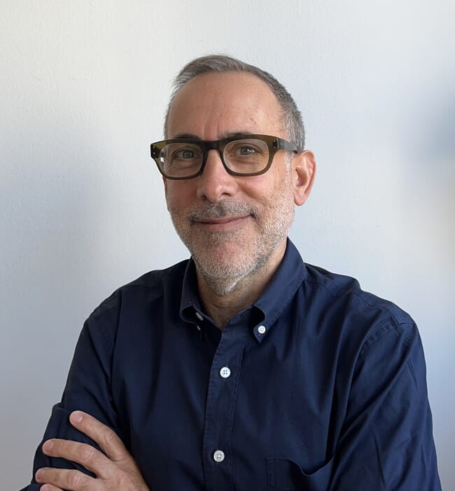 A headshot of a man in a blue shirt.