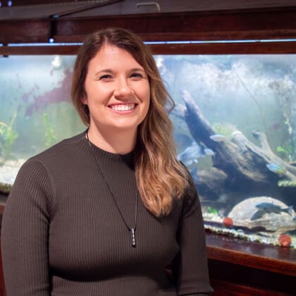 a woman sitting in front of a fish tank