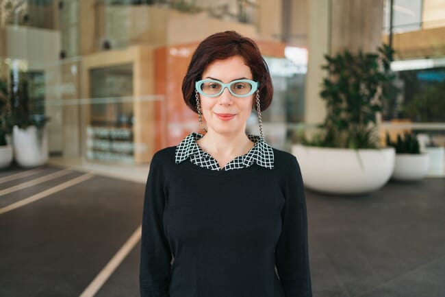 A headshot of a woman infront of an Australian university.