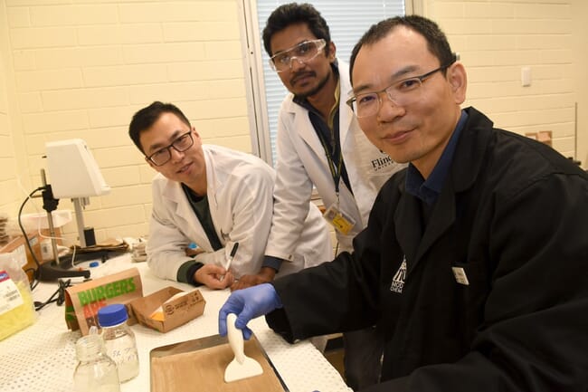 three men in a laboratory