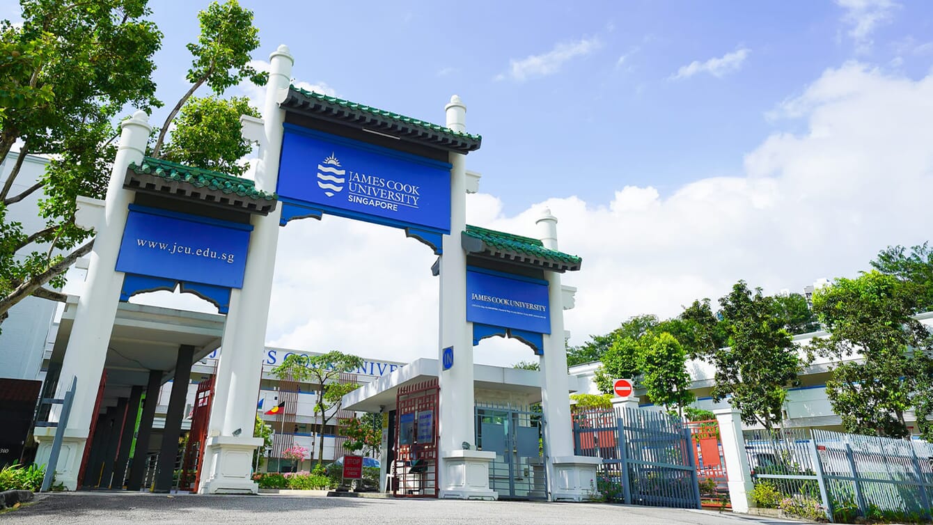 A photo of a university entrance on a sunny day in Singapore.
