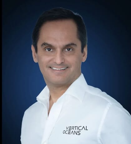 Portrait of Patrick Vizzone in a white business shirt with Vertical Ocean logo in black.