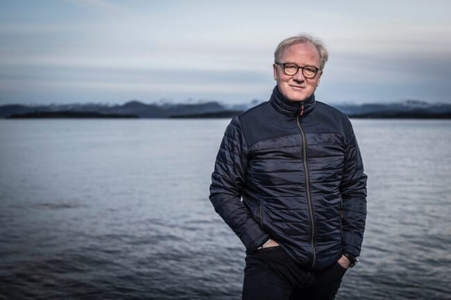 a man standing in front of the sea.