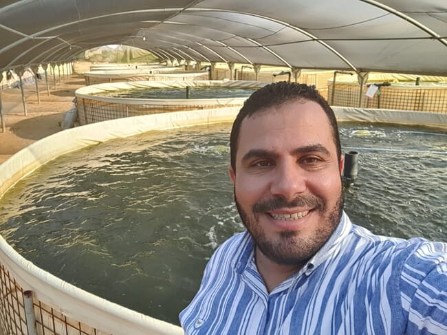 Headshot of man with water tank in the background