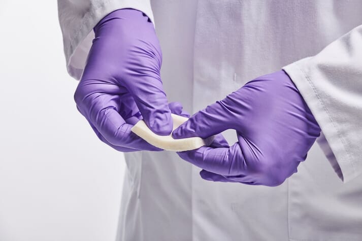 person in a lab coat and gloves