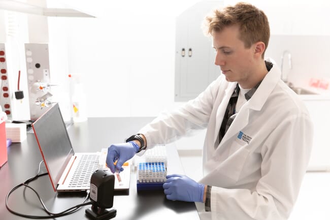 Um homem em um jaleco de laboratório trabalhando em um laboratório