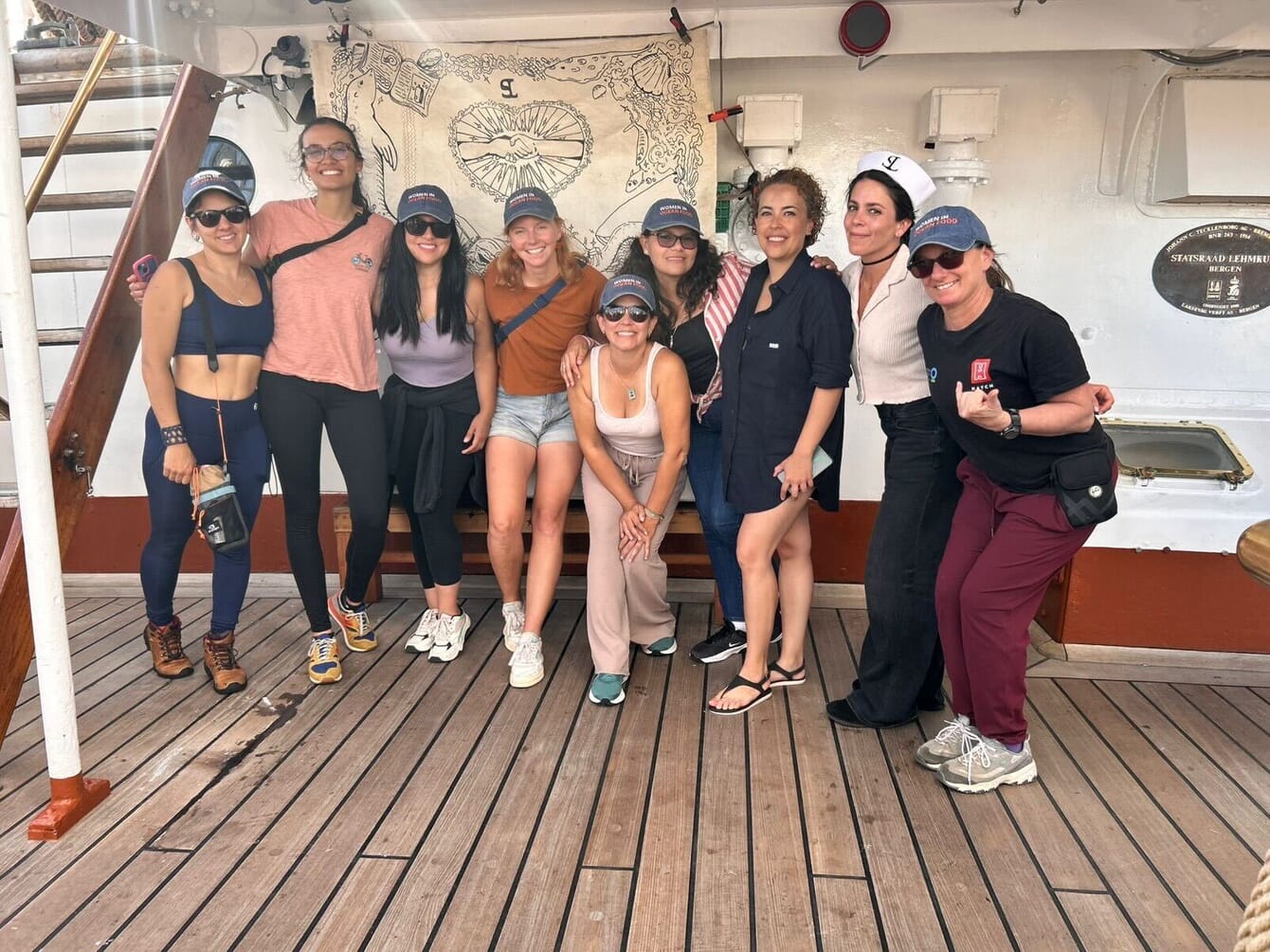 A group of women posing for a photo abroad a Norwegian tall ship.