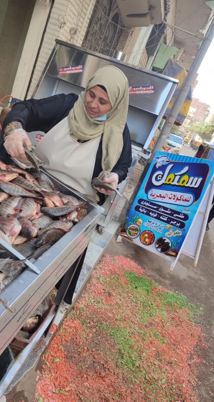 Uma mulher processando e vendendo peixes