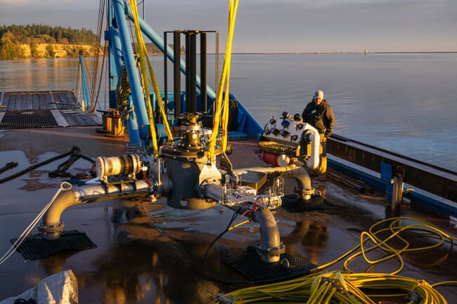 A man with a monitoring array on a ship deck.