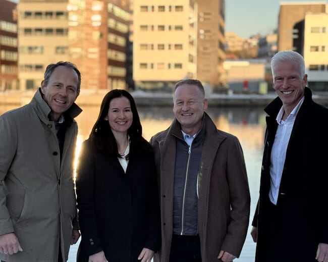 A group of four people posing for a photograph by a canal.