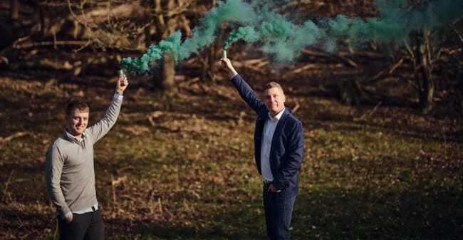 two men standing in the woods