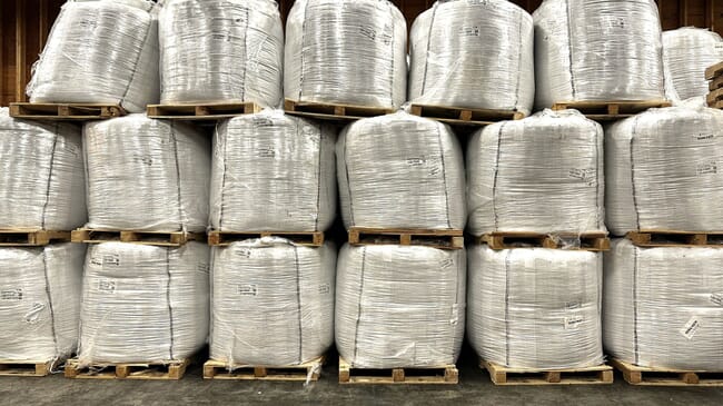 Large feed bags stacked in a warehouse.