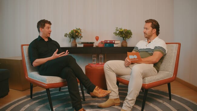 Two people having a filmed discussion in a studio.