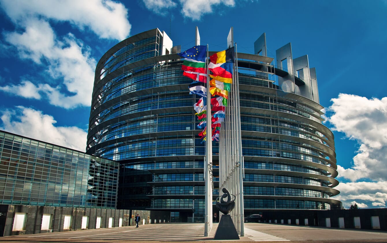 A view of a building with flags on a sunny day.