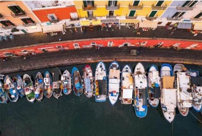 A group of artisanal fishing vessels on a port in Italy.