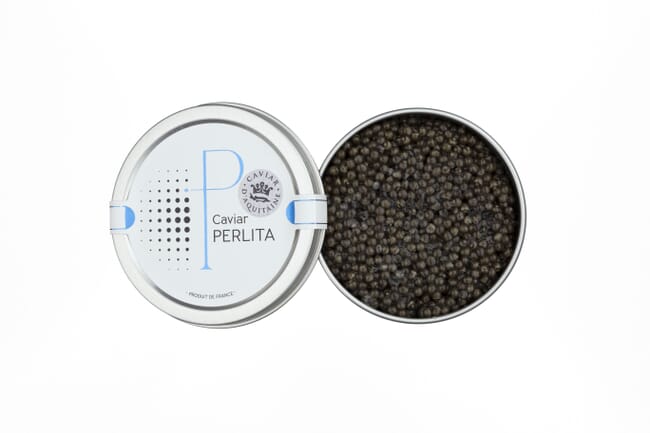 Uma caixa de metal redonda aberta com caviar