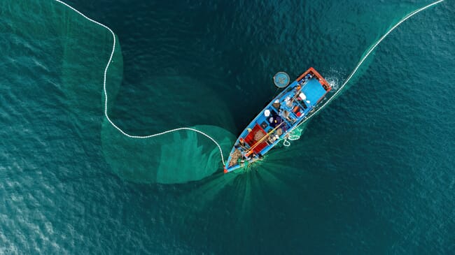 A fishing boat casting out nets.