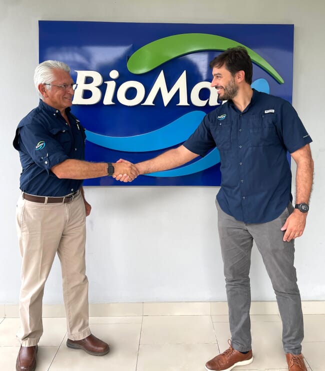 Dois funcionários da BioMar apertando as mãos.