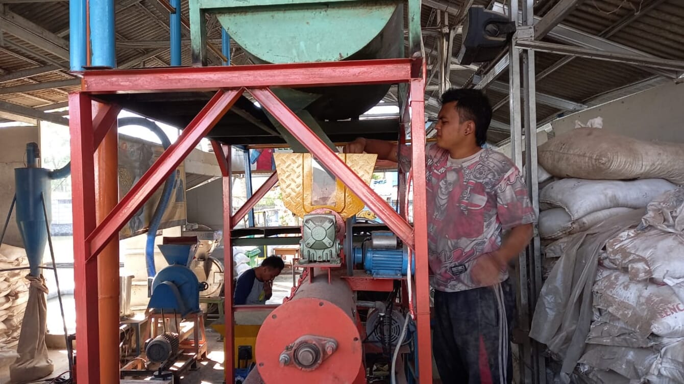 Man working on a large feed machine