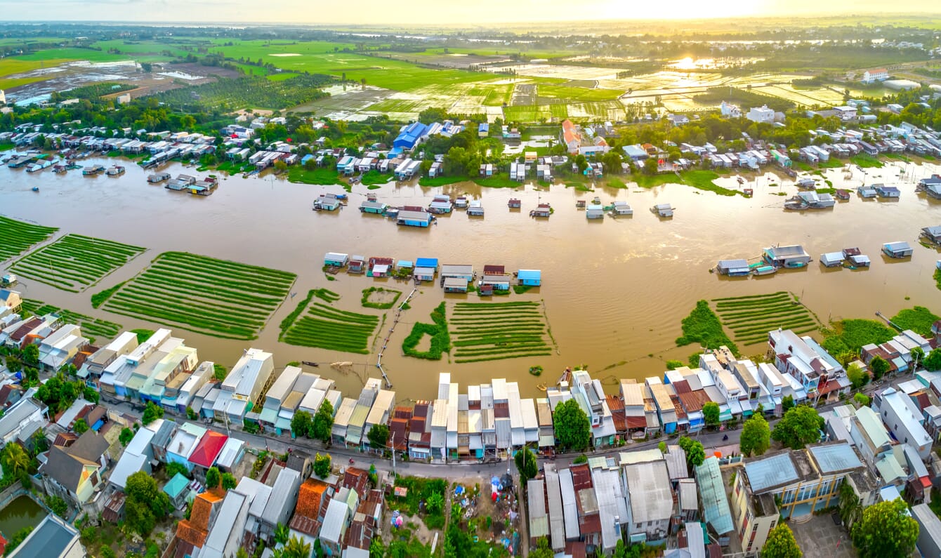 Aerial view of houses along a flooded riverbank.