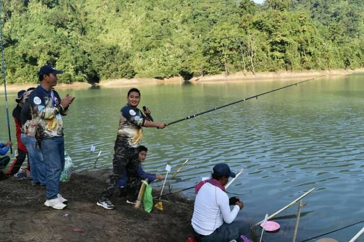 People fishing along the banks of a lake