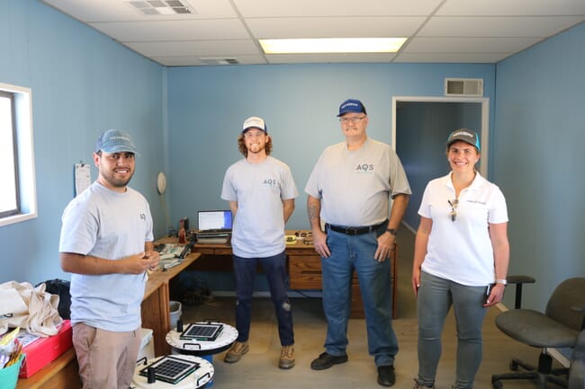 Four people standing in a room.