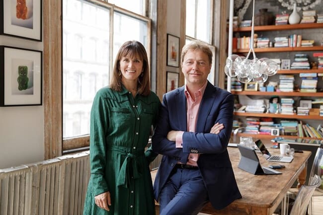 two people standing near a desk