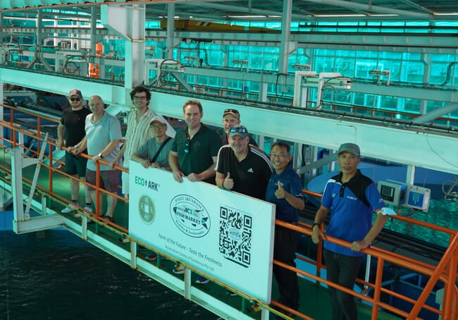 Group of people smiling at the camera from a metal bridge