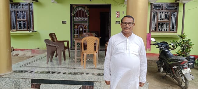 A man standing in front of a house.