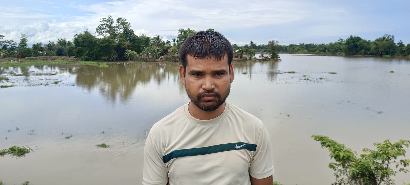 A man standing in front of a pond.