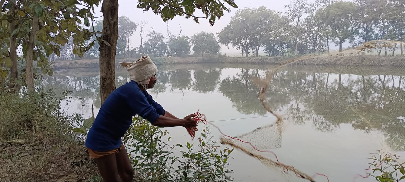 Um homem lançando uma rede de pesca.