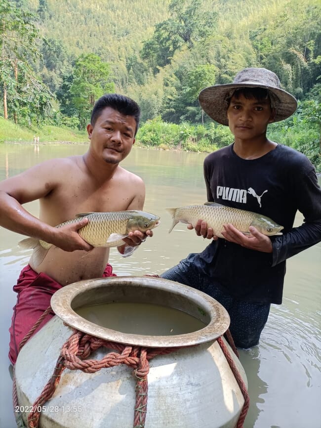 Two men holding carp