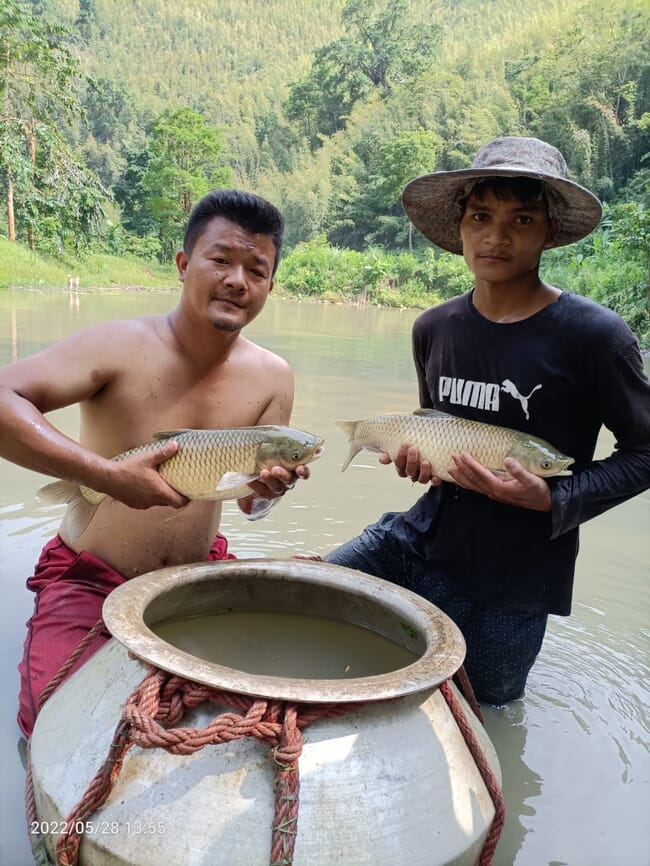 Dos hombres sosteniendo una carpa